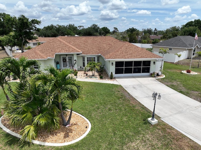 3984 Holin Ln, North Port, FL 34287 - view of front of house featuring fence, french doors, concrete driveway, a garage, and a front lawn