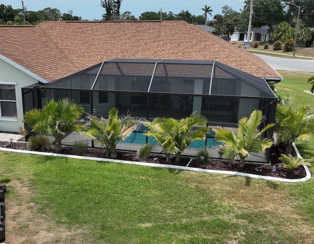 3984 Holin Ln, North Port, FL 34287 - rear view of property featuring a lawn, a shingled roof, and glass enclosure
