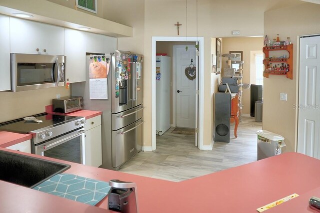 3984 Holin Ln, North Port, FL 34287 - kitchen featuring white cabinets, stainless steel appliances, baseboards, a toaster, and visible vents