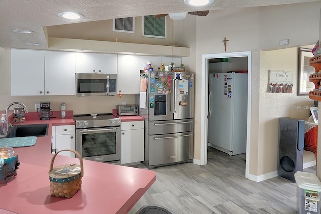 3984 Holin Ln, North Port, FL 34287 - kitchen with a sink, stainless steel appliances, white cabinetry, and visible vents