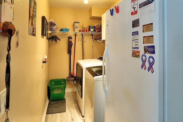 3984 Holin Ln, North Port, FL 34287 - clothes washing area featuring baseboards, laundry area, washing machine and dryer, and light wood-style flooring