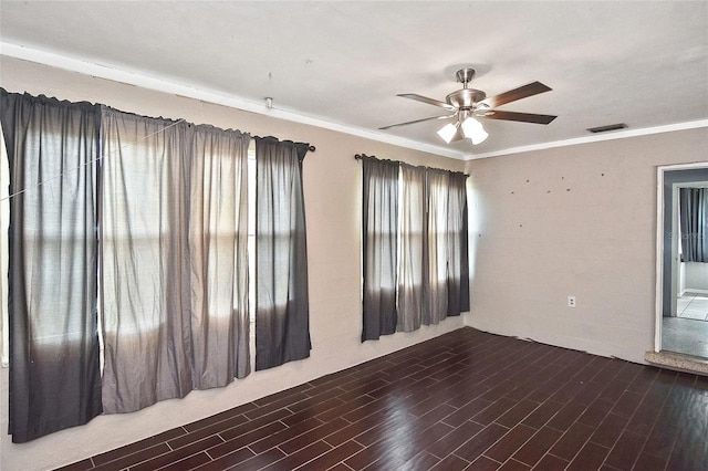 spare room with visible vents, a ceiling fan, crown molding, and wood finished floors