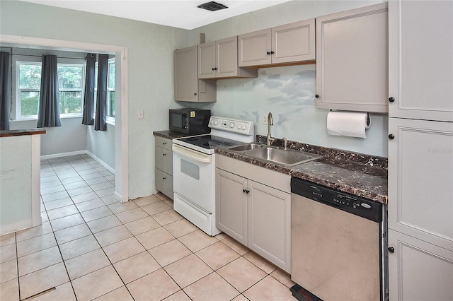 kitchen with stainless steel dishwasher, a sink, black microwave, dark countertops, and electric stove