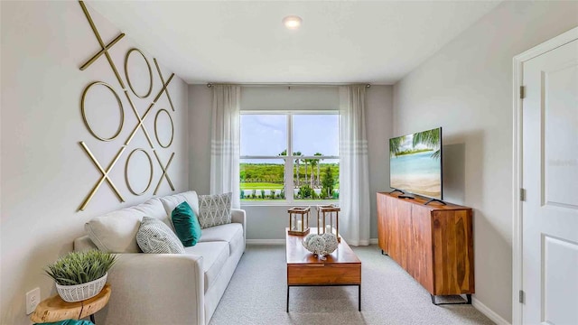 living room with baseboards and light colored carpet