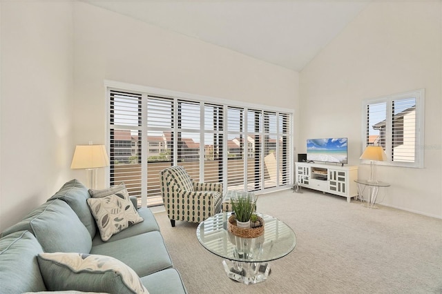 living room with carpet flooring, high vaulted ceiling, and baseboards