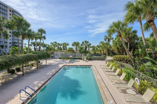 community pool with a community hot tub, a patio area, and fence