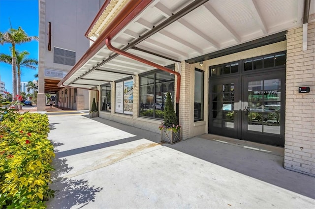 property entrance featuring french doors and brick siding