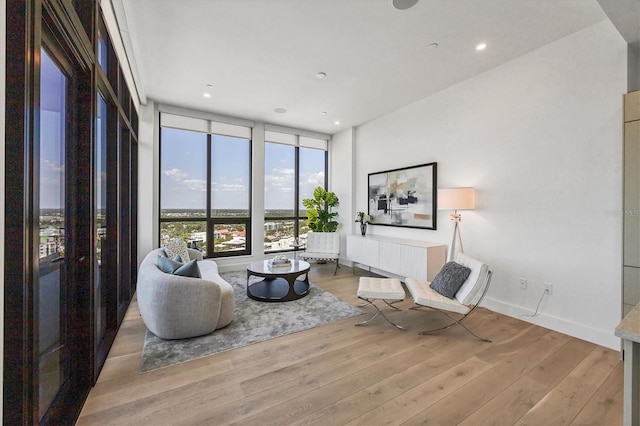 sitting room featuring wood finished floors, recessed lighting, and baseboards