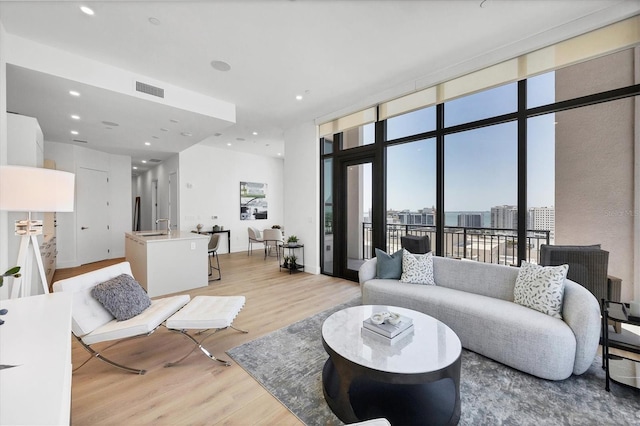 living area featuring light wood-style floors, expansive windows, and recessed lighting