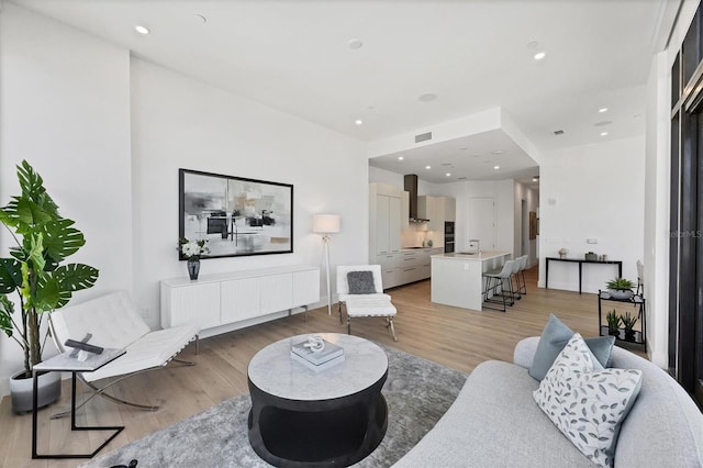 living area with light wood finished floors and recessed lighting