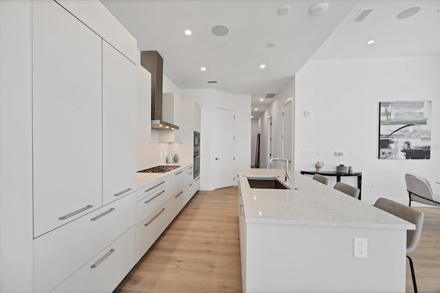 kitchen featuring a sink, modern cabinets, a breakfast bar area, stainless steel gas stovetop, and recessed lighting