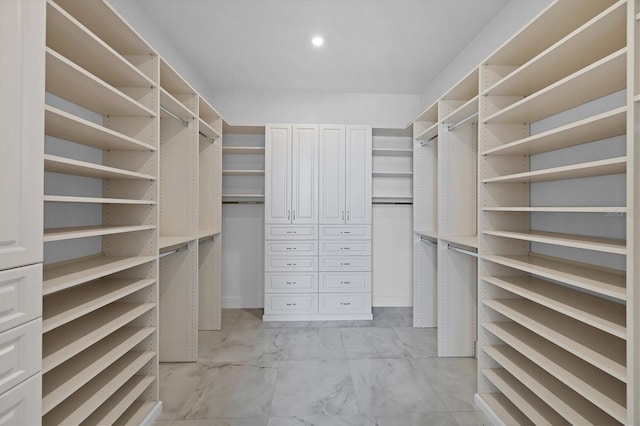 walk in closet featuring light marble finish flooring