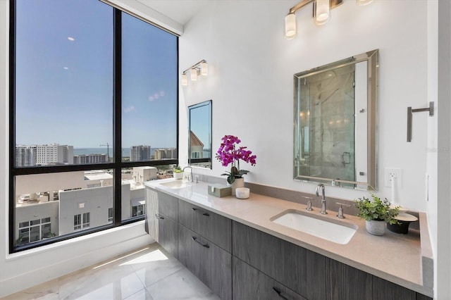bathroom featuring a stall shower, marble finish floors, a wall of windows, double vanity, and a view of city