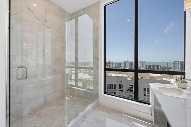 bathroom with marble finish floors, a stall shower, a view of city, and vanity