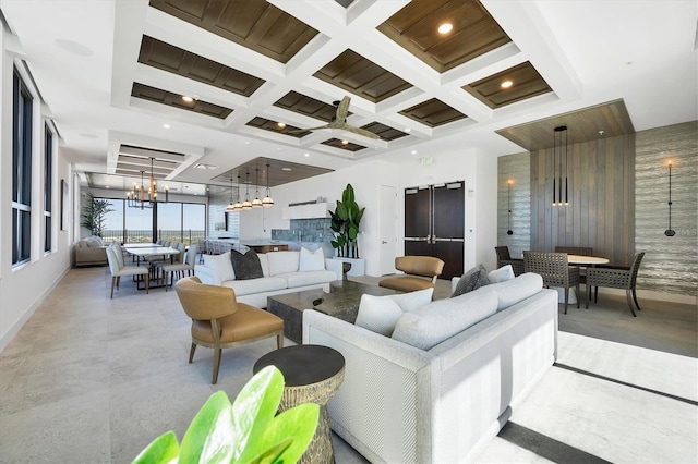 living room featuring coffered ceiling, a chandelier, baseboards, and beamed ceiling