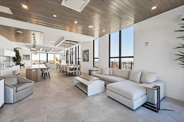 living room featuring baseboards, wood ceiling, and recessed lighting