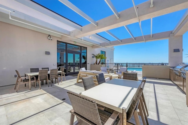 view of patio featuring outdoor dining area, french doors, a water view, and grilling area