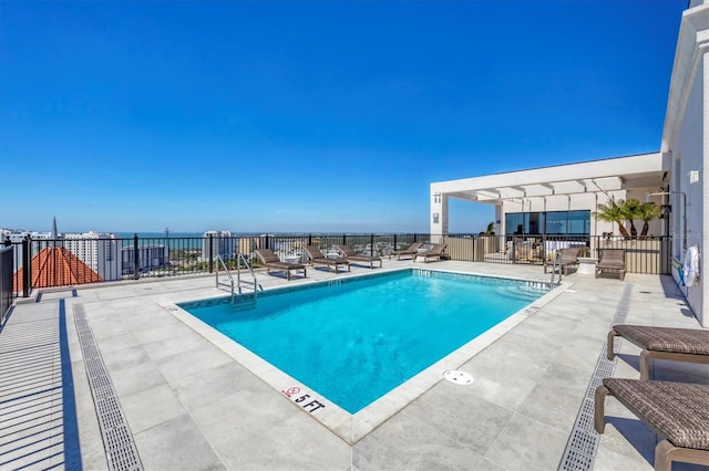 community pool with fence and a patio