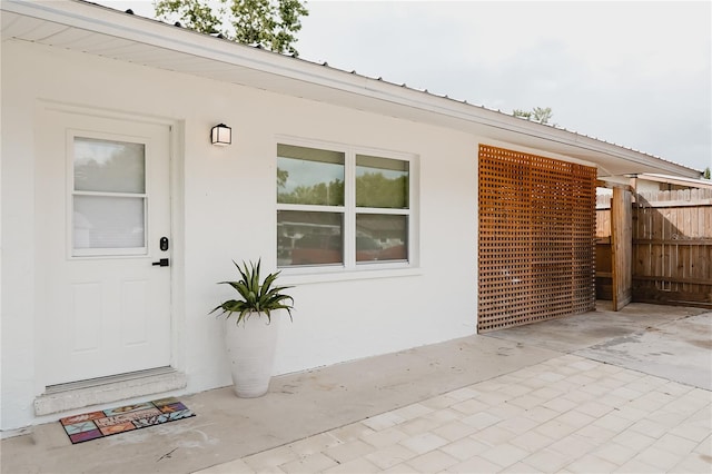 2300 Stratford Dr, Sarasota, FL 34232 - doorway to property featuring fence, stucco siding, and a patio area