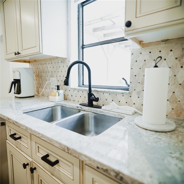2300 Stratford Dr, Sarasota, FL 34232 - kitchen with a sink, tasteful backsplash, cream cabinetry, light stone counters, and plenty of natural light