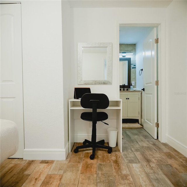 2300 Stratford Dr, Sarasota, FL 34232 - corridor featuring light wood finished floors, a sink, and baseboards
