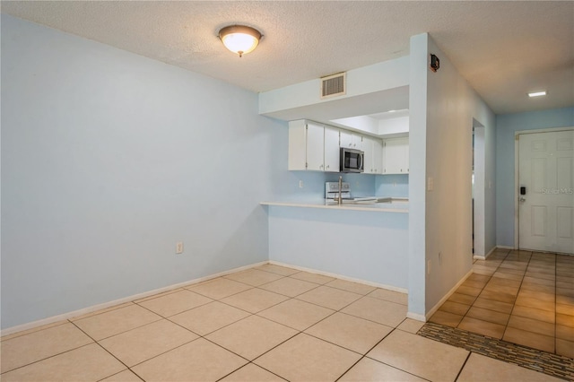 3610 54th St W Unit B4, Bradenton, FL 34209 - kitchen featuring stainless steel microwave, light countertops, light tile patterned floors, white electric range oven, and white cabinetry