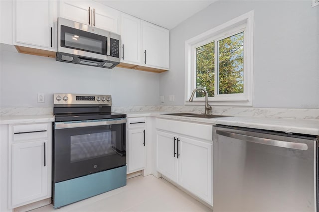 3095 Pinetree St, Port Charlotte, FL 33952 - kitchen with stainless steel appliances, a sink, light stone counters, and white cabinetry