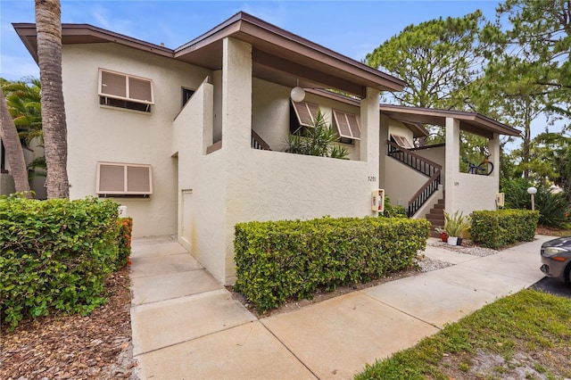 view of side of property with stucco siding and stairway