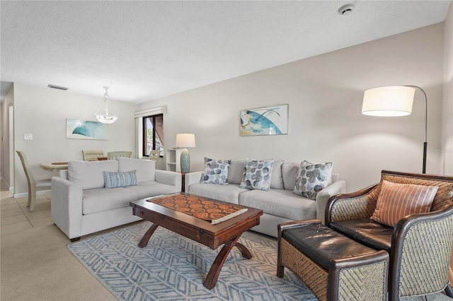 living room featuring light carpet, baseboards, and a textured ceiling