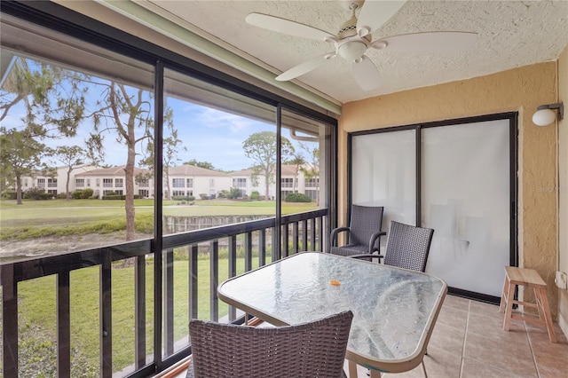 sunroom / solarium featuring ceiling fan, outdoor dining area, and a residential view