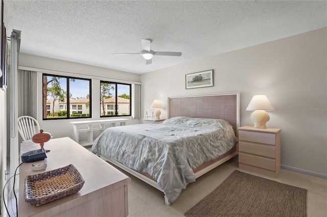 bedroom featuring carpet, a textured ceiling, and a ceiling fan