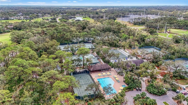 aerial overview of property's location with a pool area and a heavily wooded area