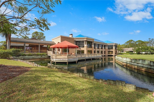 dock area featuring a gazebo, a water view, and a lawn