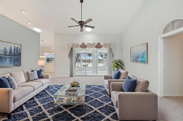 living room with carpet flooring, ceiling fan, plenty of natural light, vaulted ceiling, and baseboards