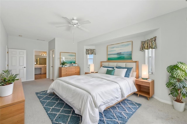bedroom with carpet floors, baseboards, a ceiling fan, and ensuite bathroom
