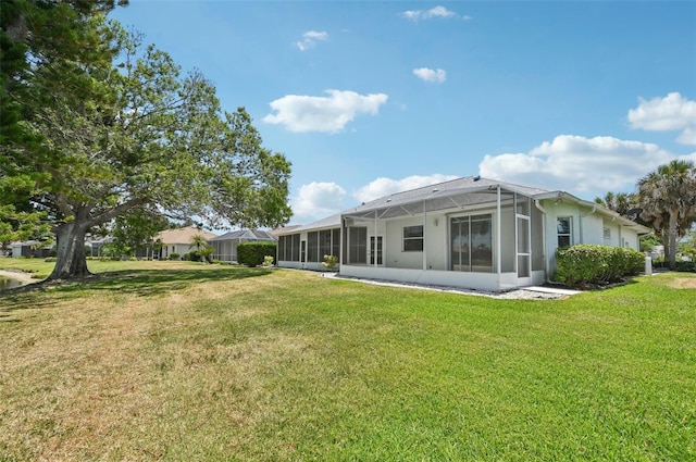 back of property with a yard and a lanai