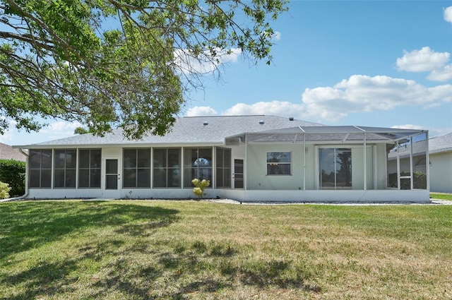 rear view of house featuring a sunroom, a yard, and roof with shingles