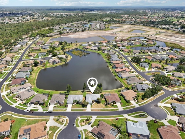 aerial view of property and surrounding area featuring nearby suburban area and a large body of water