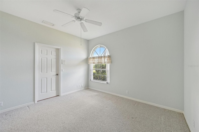 spare room with carpet, a ceiling fan, and baseboards