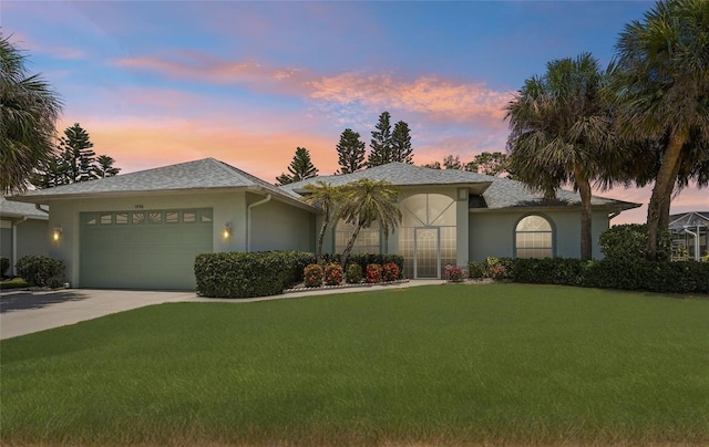 5596 Sabal Trace Dr, North Port, FL 34287 - ranch-style house with stucco siding, a garage, a yard, and concrete driveway