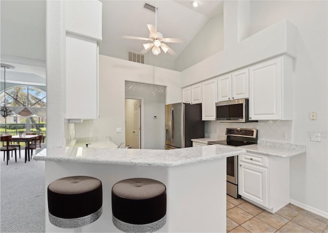 5596 Sabal Trace Dr, North Port, FL 34287 - kitchen featuring stainless steel appliances, ceiling fan, white cabinetry, a peninsula, and high vaulted ceiling