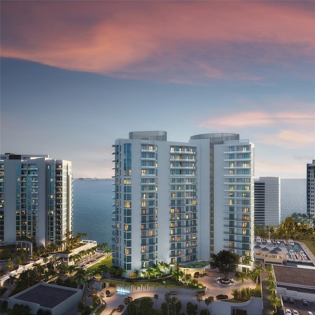 property at dusk featuring a water view and a city view