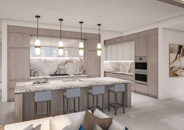 kitchen featuring a kitchen bar, modern cabinets, a sink, multiple ovens, and an island with sink