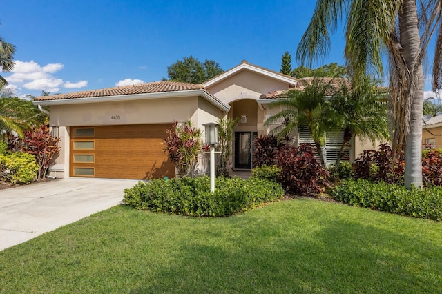 mediterranean / spanish house featuring an attached garage, a tile roof, stucco siding, a front yard, and driveway