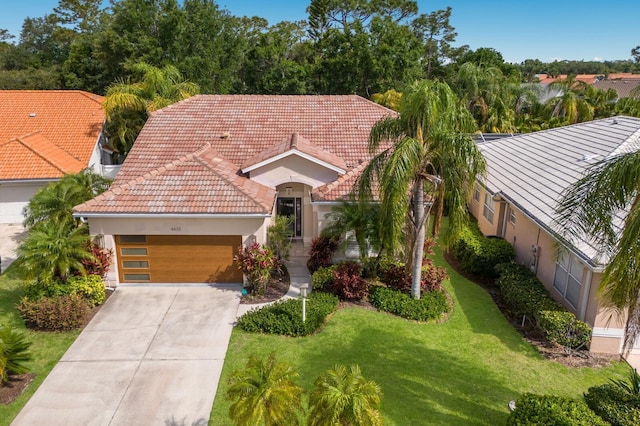 mediterranean / spanish-style house featuring a garage, stucco siding, driveway, and a front yard