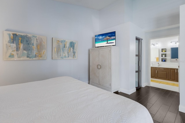 bedroom with wood tiled floor, baseboards, and connected bathroom