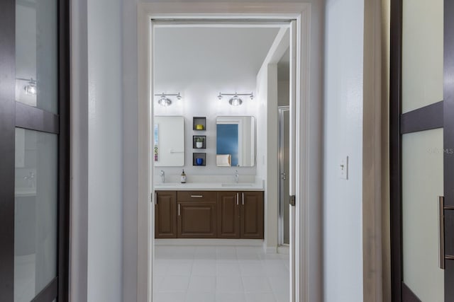 corridor with a sink and light tile patterned floors