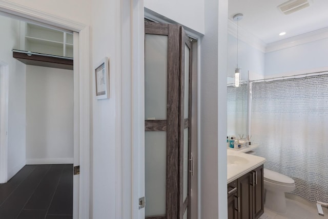 bathroom featuring vanity, crown molding, and toilet