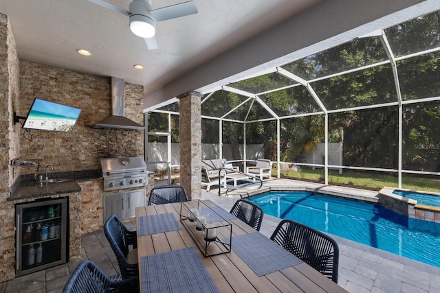 view of pool with area for grilling, exterior kitchen, a patio area, and a sink