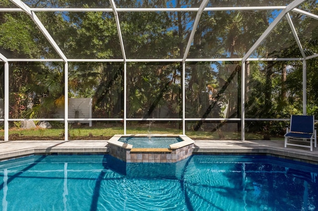 view of pool featuring glass enclosure, a pool with connected hot tub, and a patio area